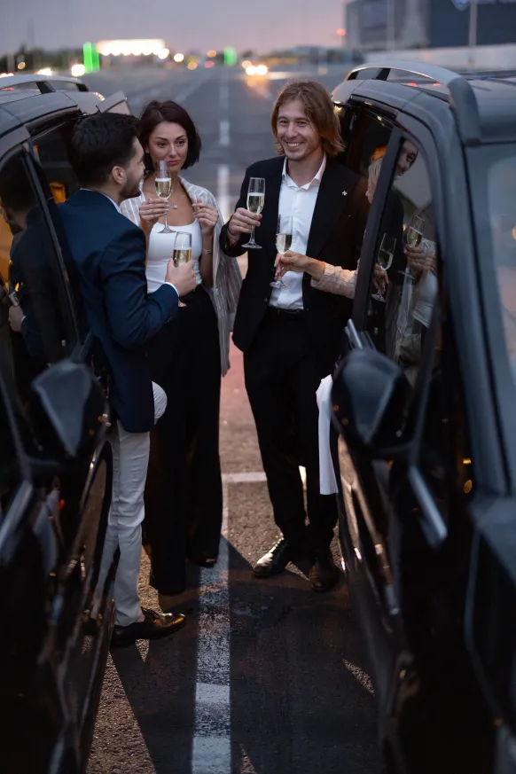 group-business-partners-have-fun-together-drinking-alcohol-while-celebrating-cars-parking-lot-nigh